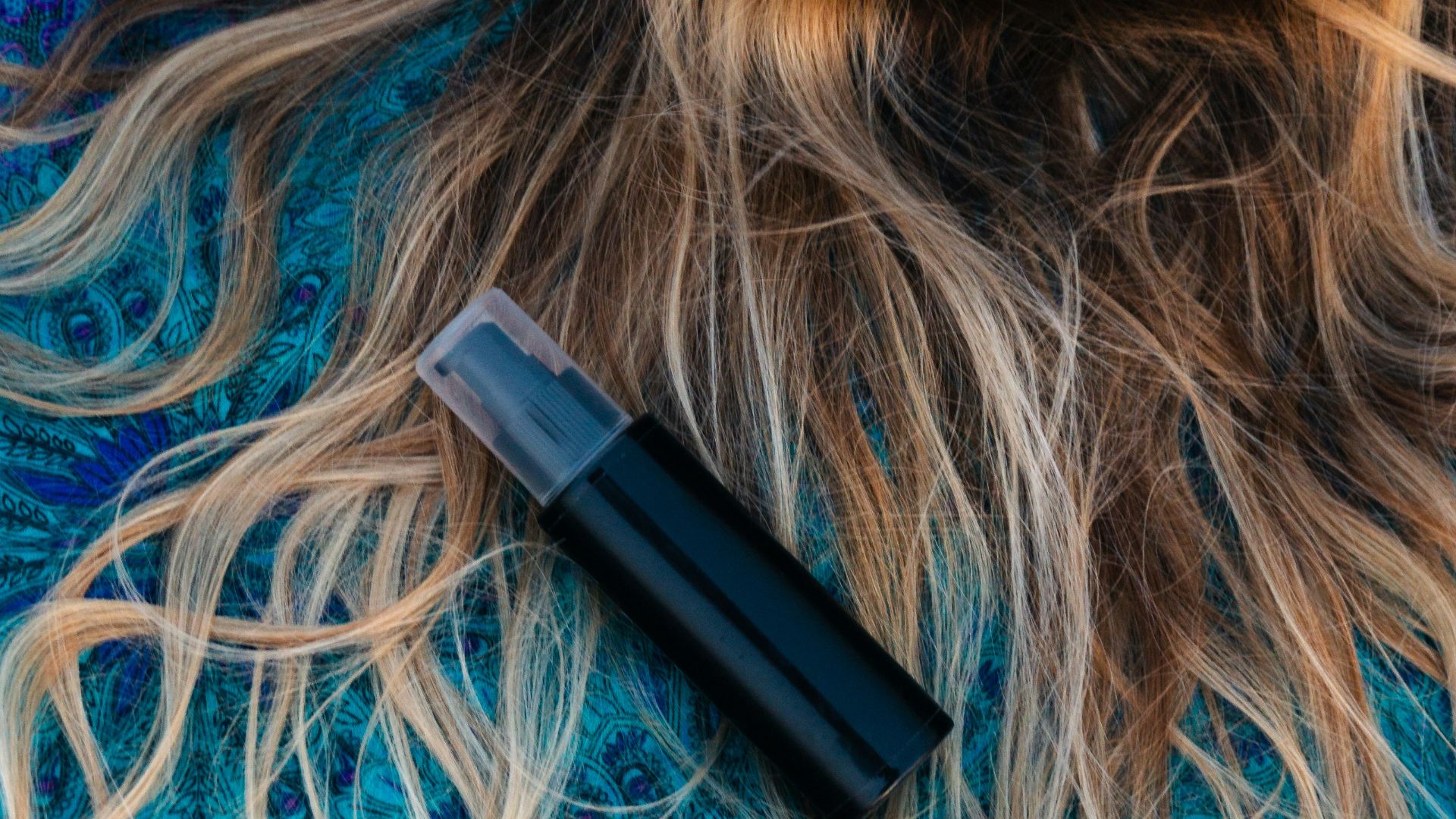 woman lying on blue floral textile