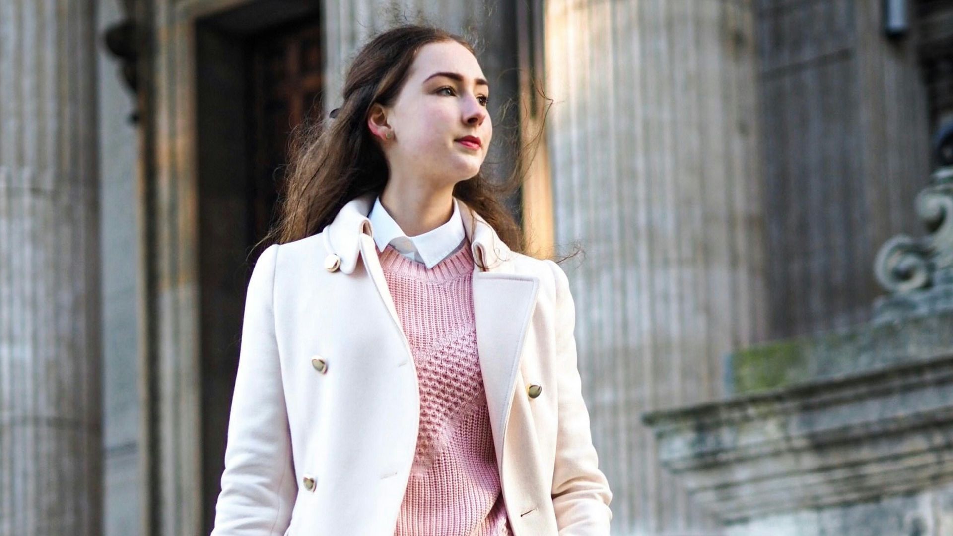 woman wearing white coat carrying crossbody bag