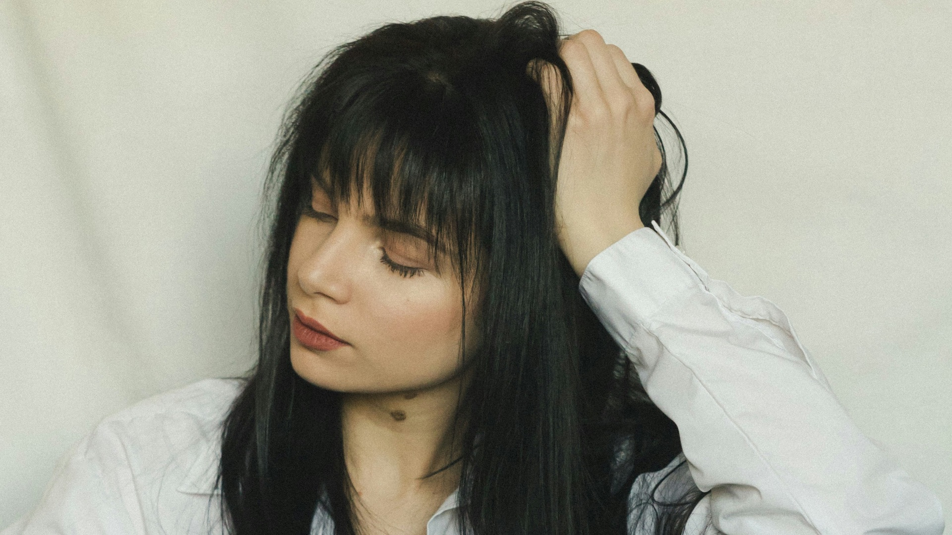 a woman with long black hair sitting on a chair