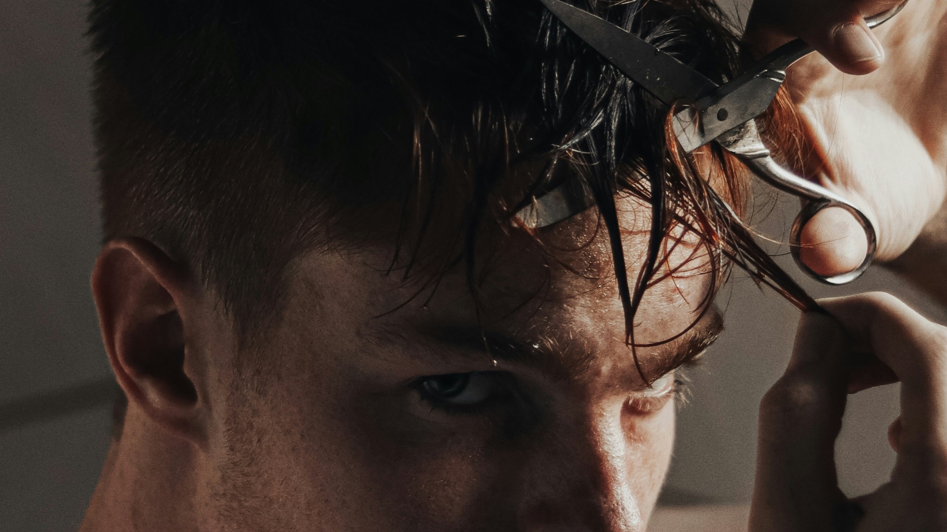 man with black hair holding hair iron