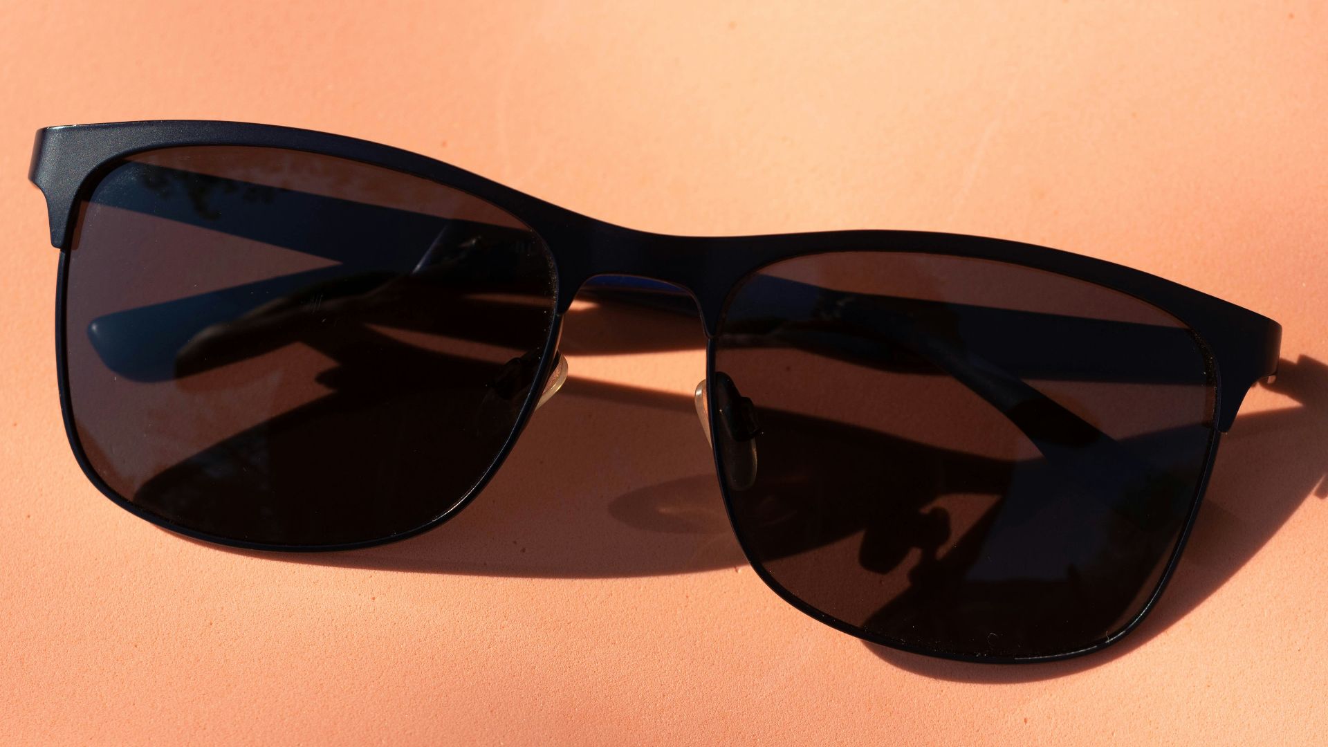 black framed sunglasses on white table