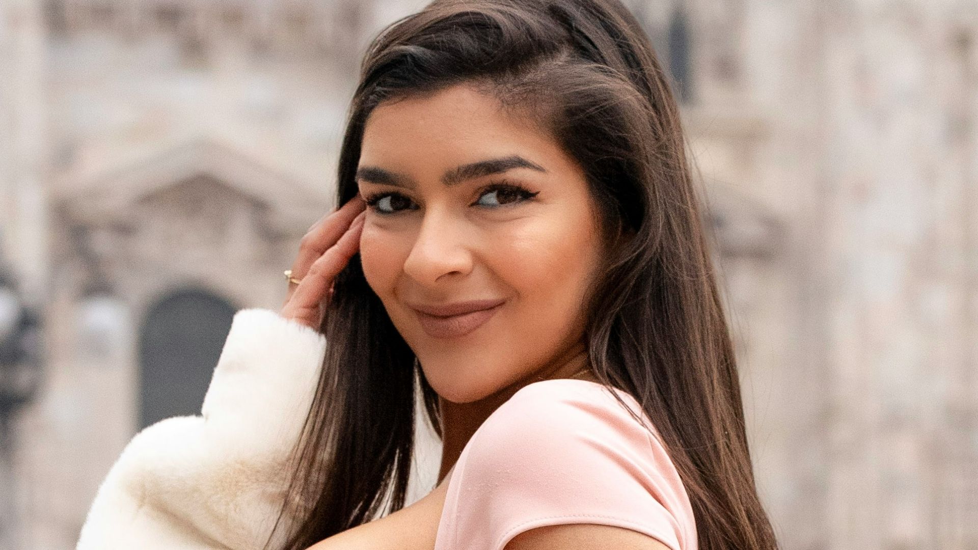 A woman poses in front of a monument.
