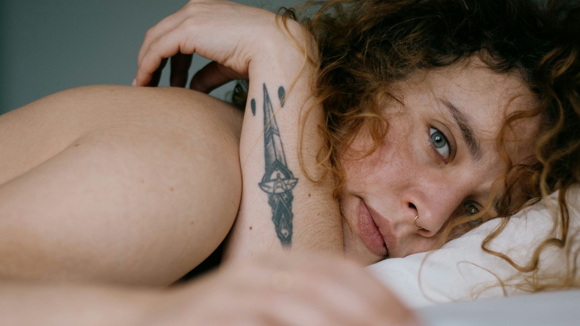 topless woman lying on bed