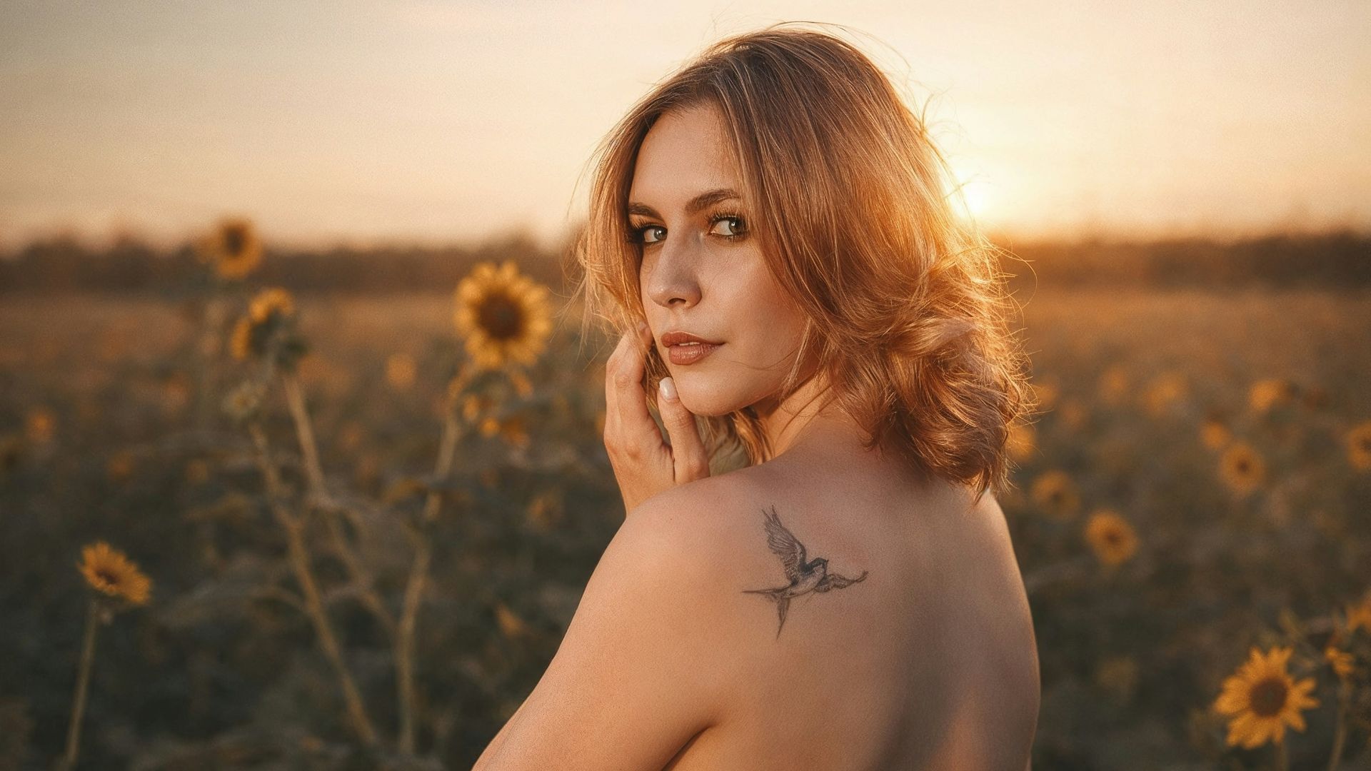 Woman in sunflower field at sunset