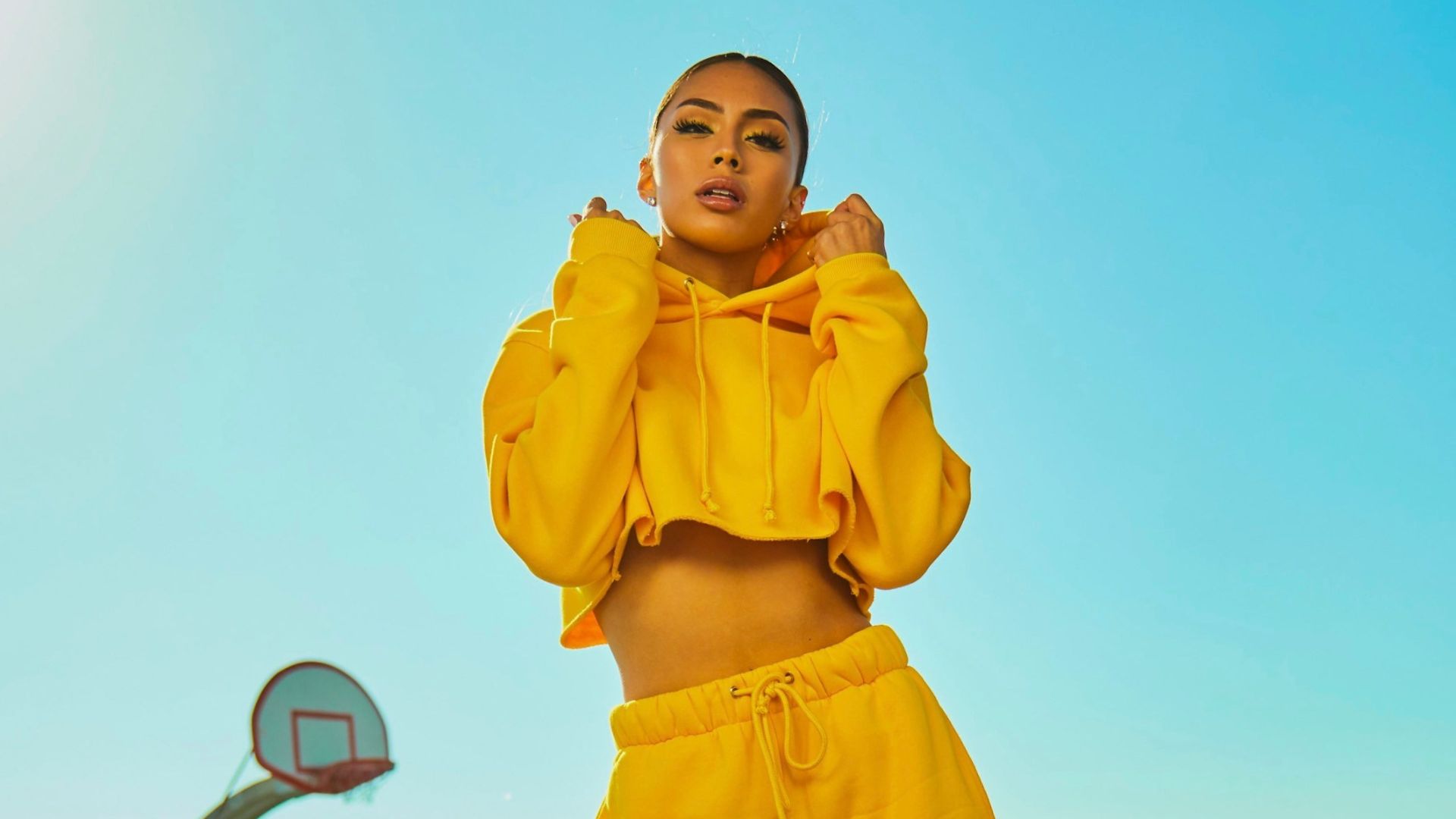 woman in yellow tracksuit standing on basketball court side
