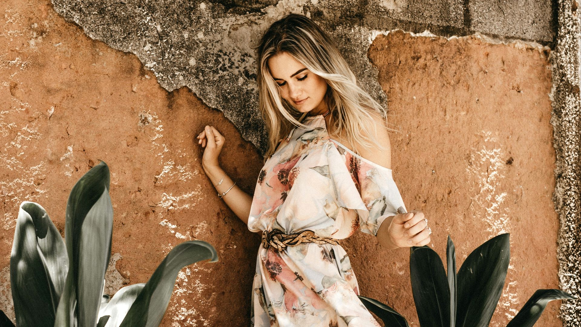 smiling woman standing near wall during daytime