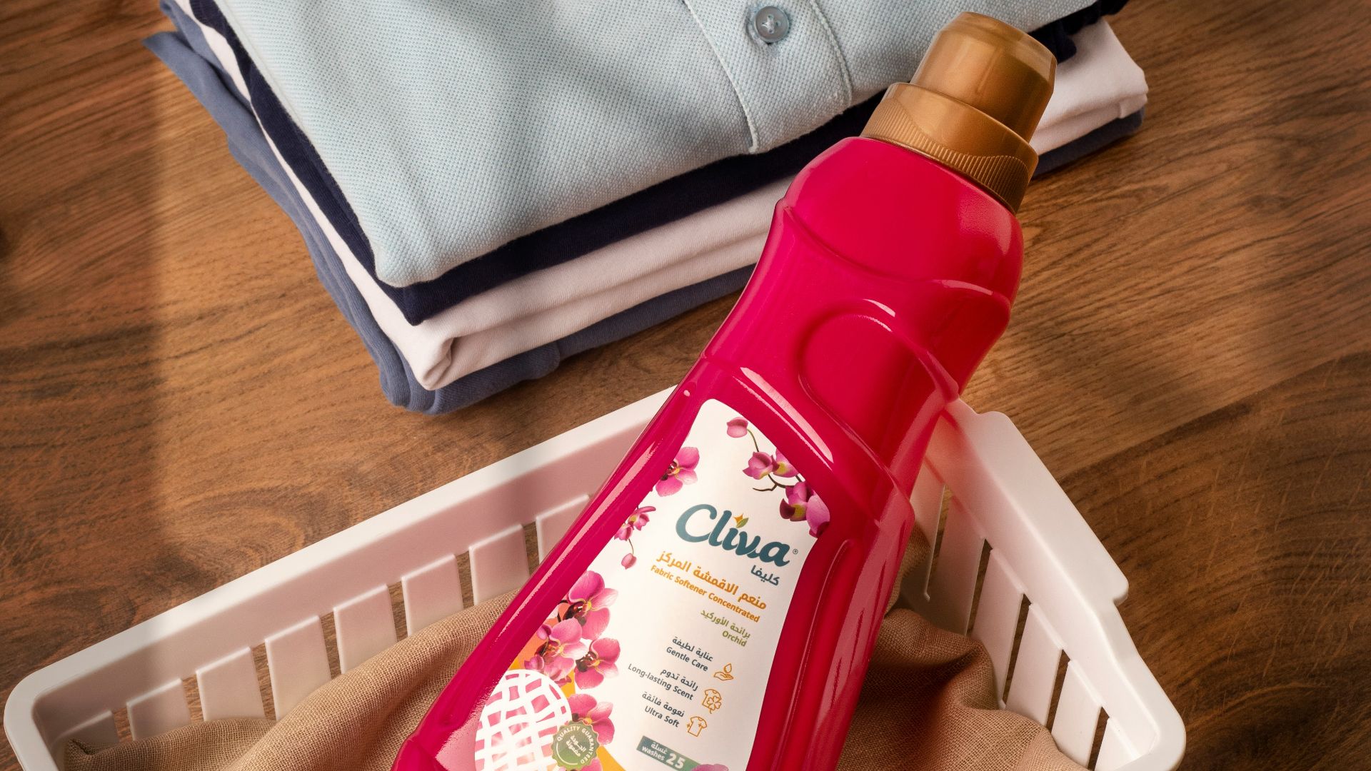 Folded clothes and a bottle of fabric softener.