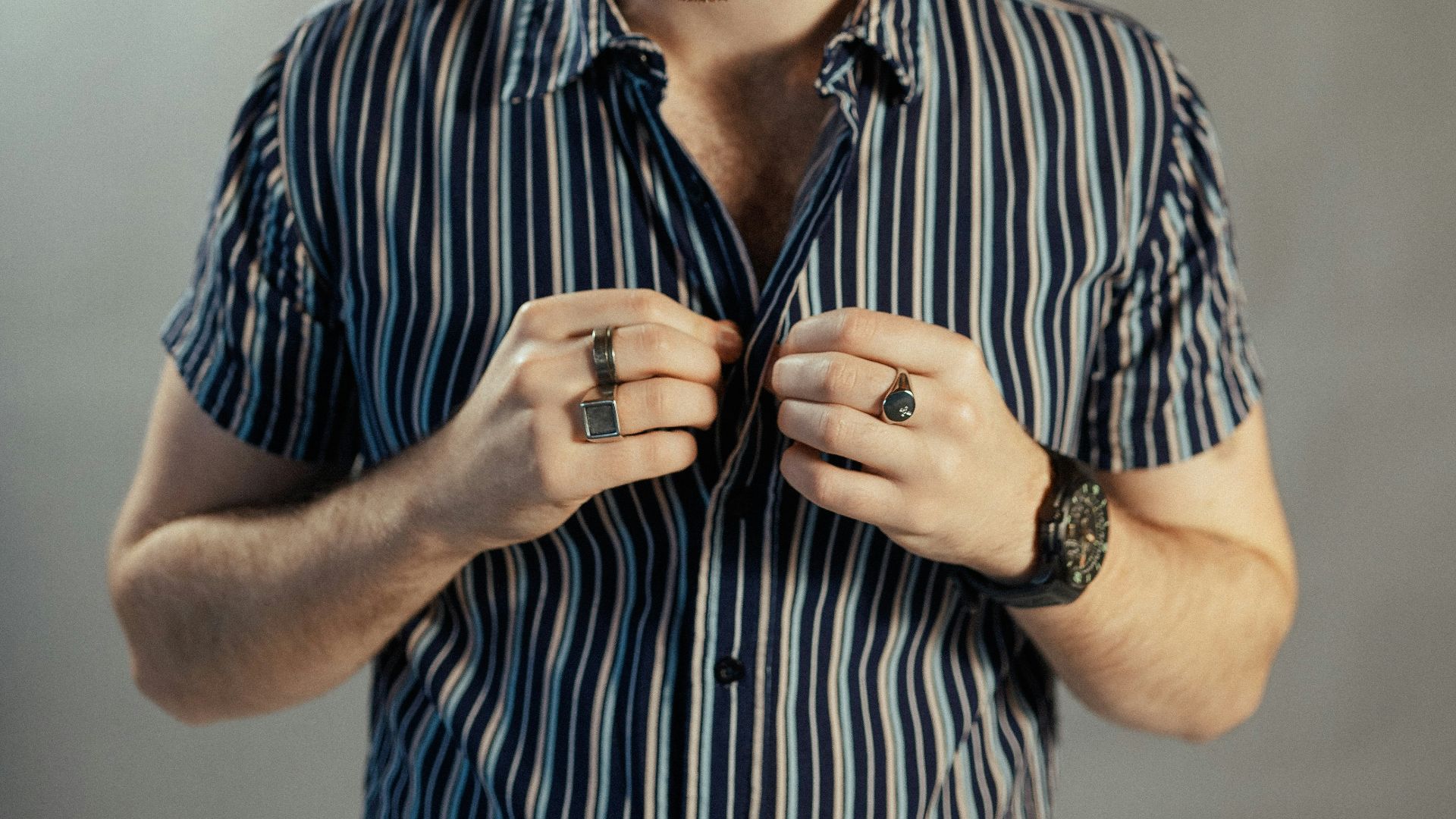 a man in a striped shirt tying his tie