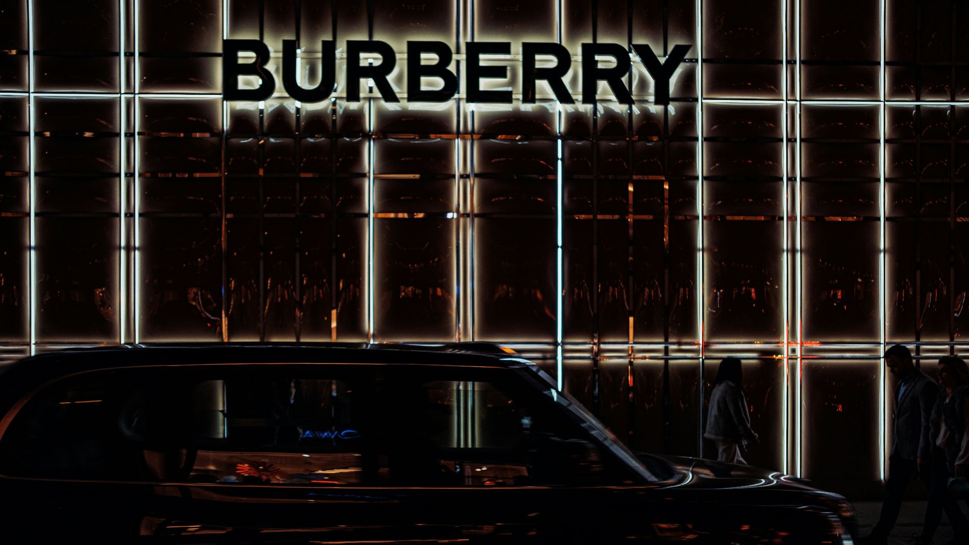 a black car parked in front of a burberry building