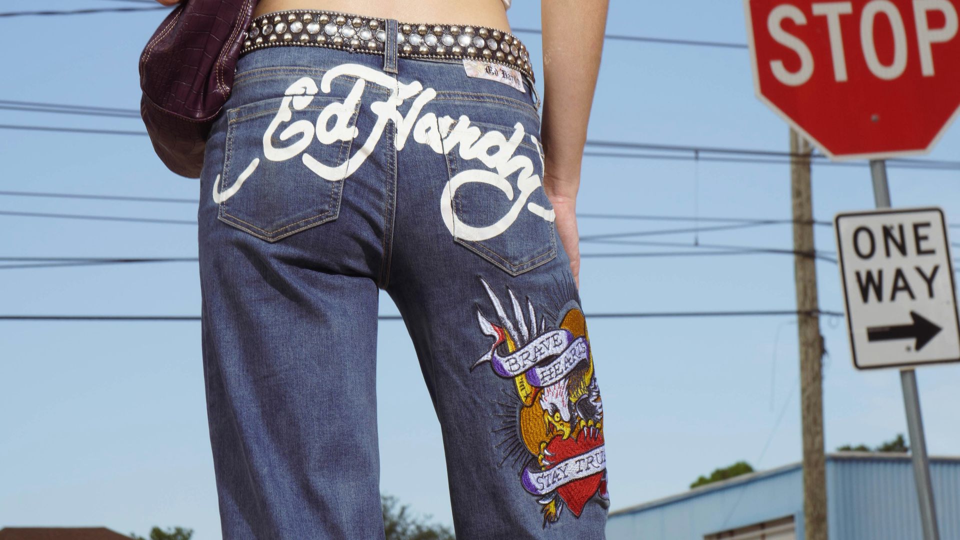 Woman wearing ed hardy jeans at a street corner
