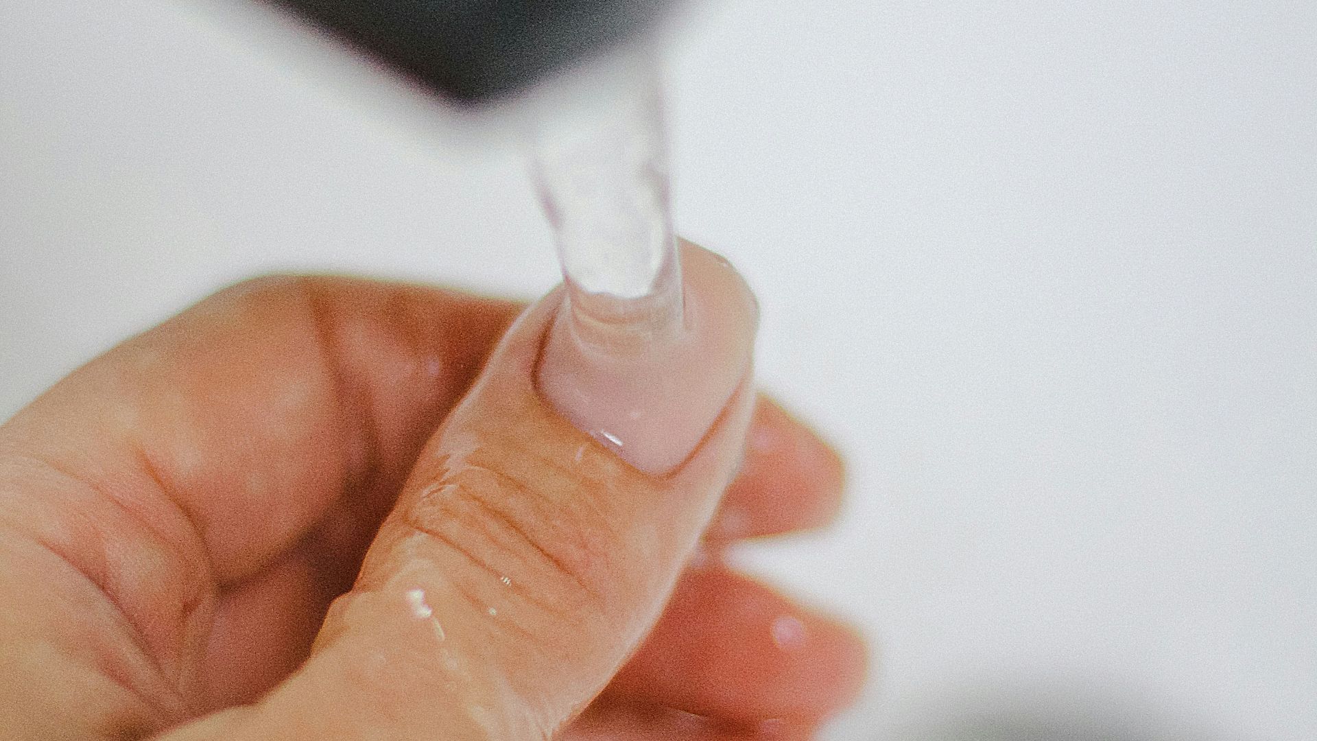 a hand holding a small light bulb