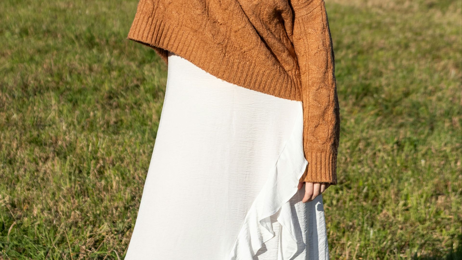 Young woman in a brown sweater and white skirt