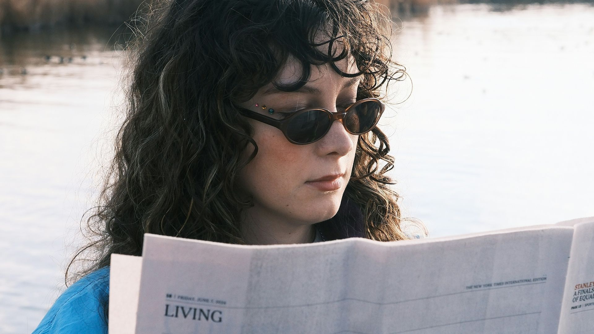 A woman sitting on a boat reading a newspaper