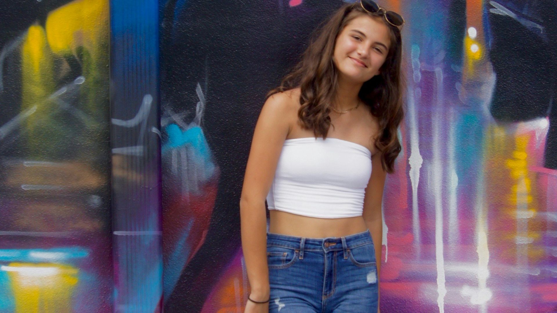 woman in white tank top and blue denim jeans