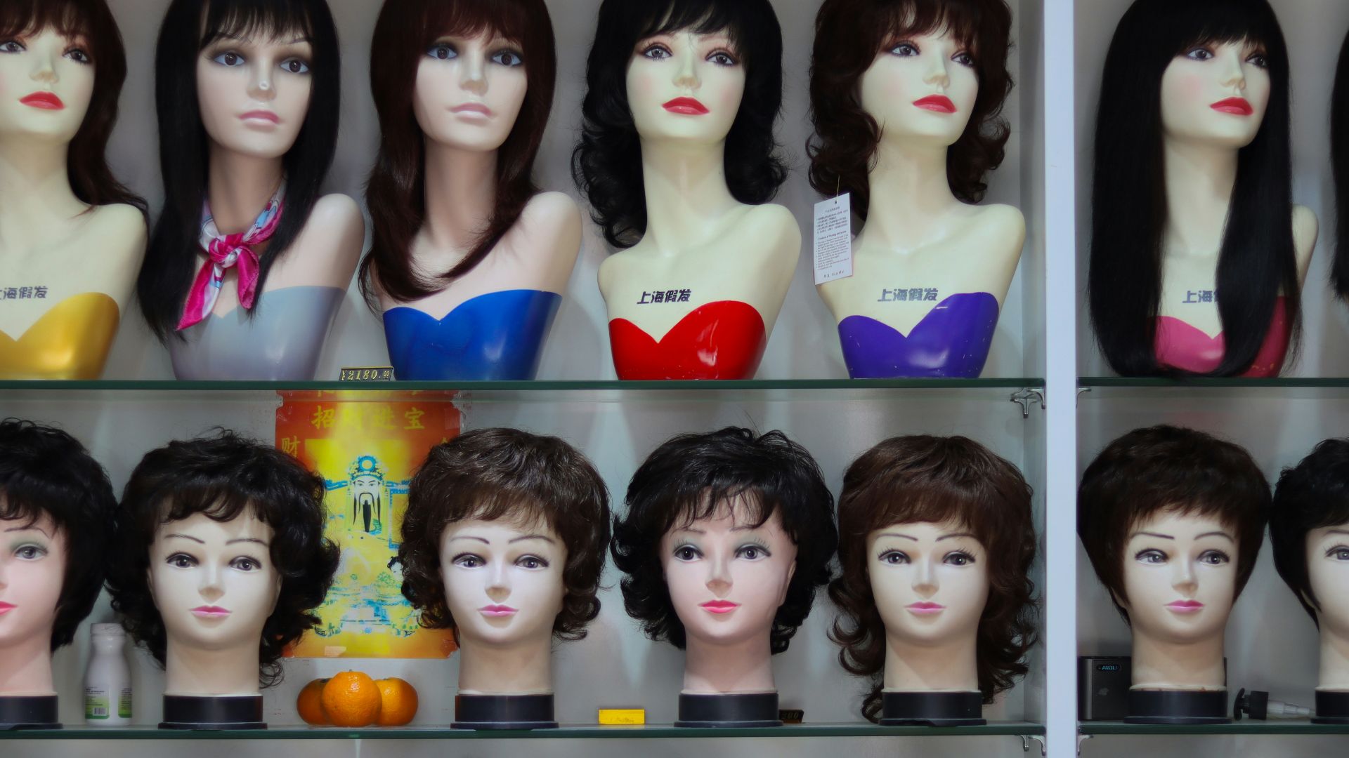 a display case filled with lots of mannequin heads