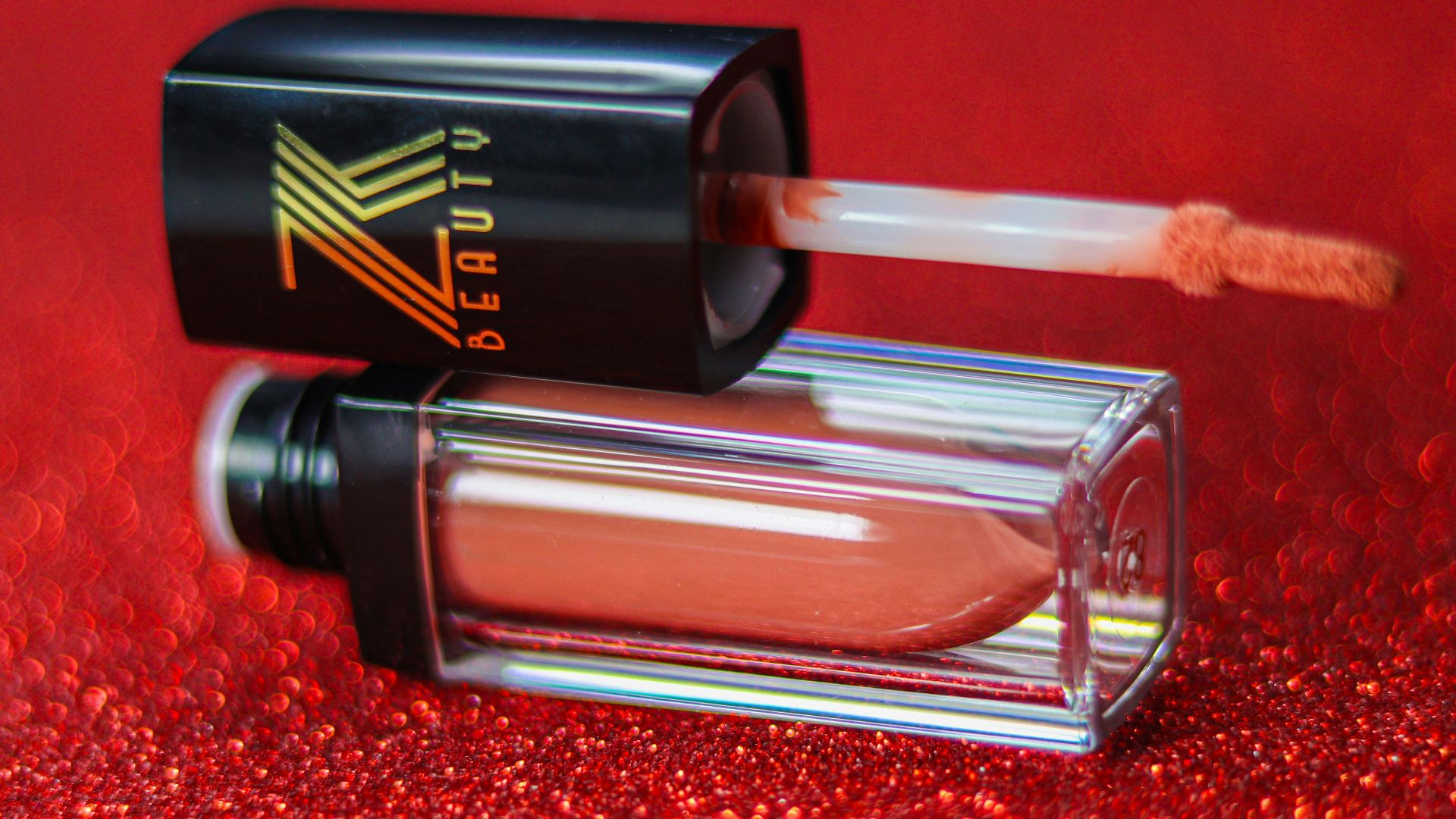 A bottle of lipstick sitting on top of a red carpet