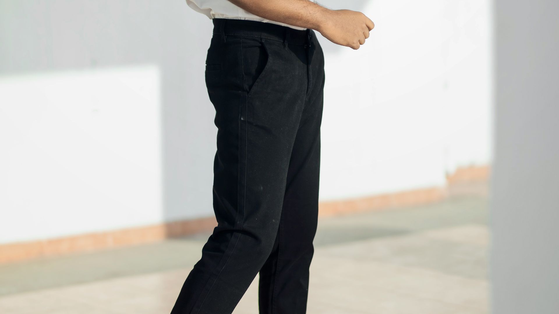 man in white t-shirt and black pants standing on white floor