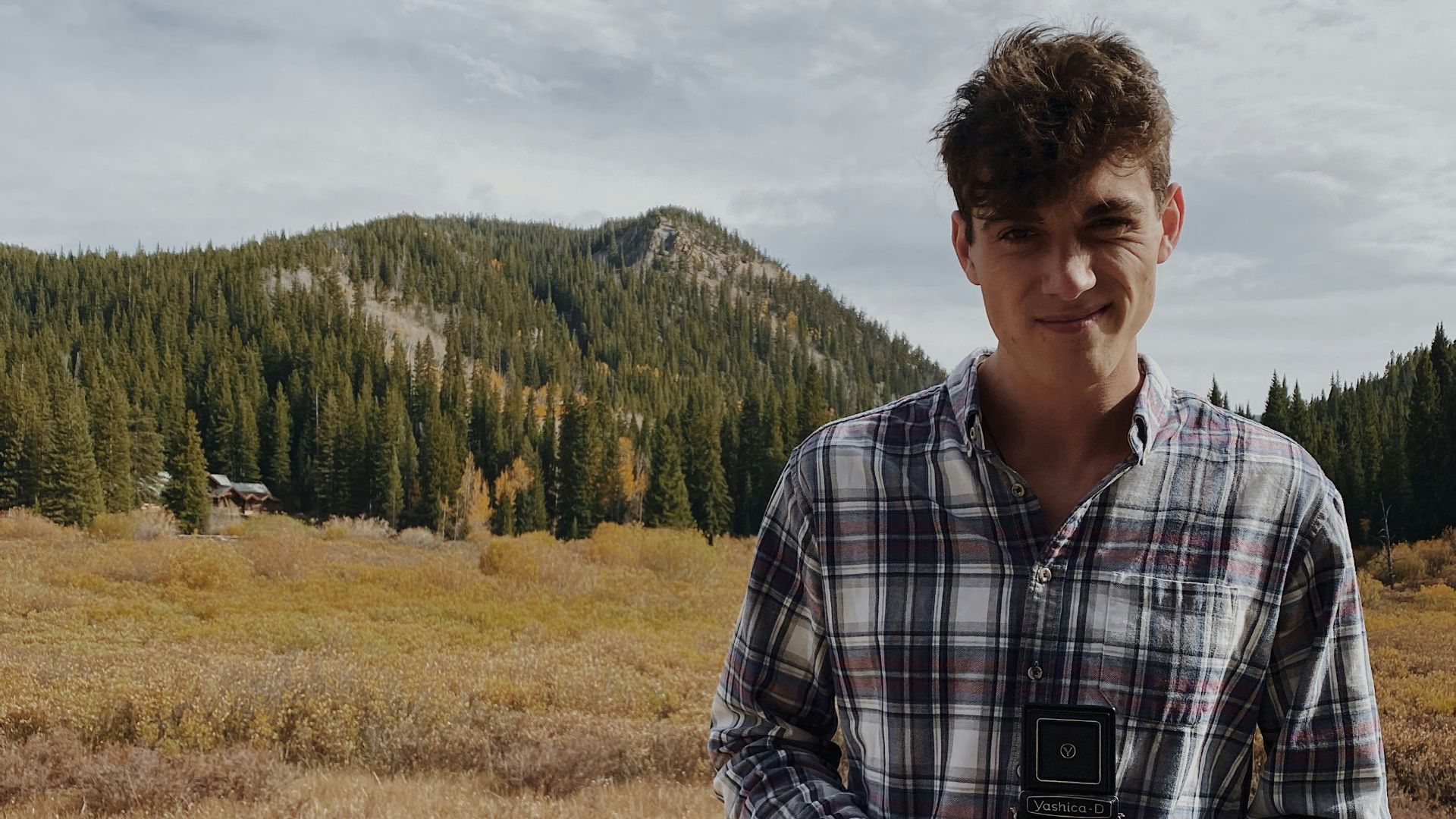 man in black and white plaid dress shirt standing on green grass field during daytime