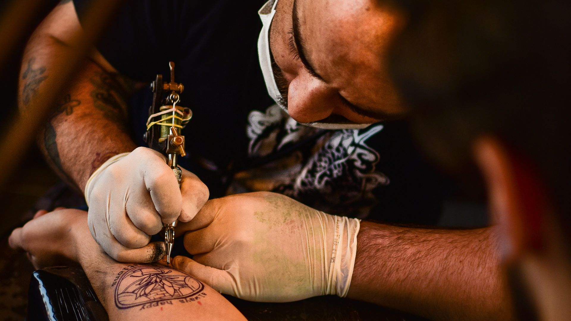 man doing tattoo on human arm