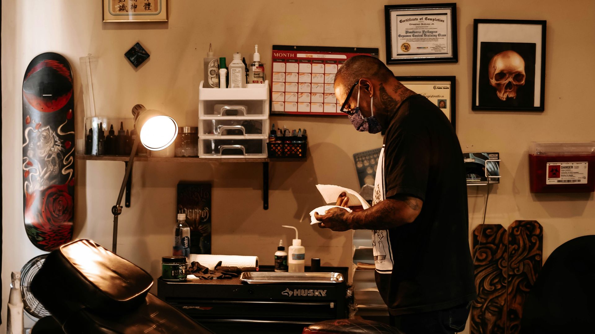 man in black t-shirt standing near brown wooden table