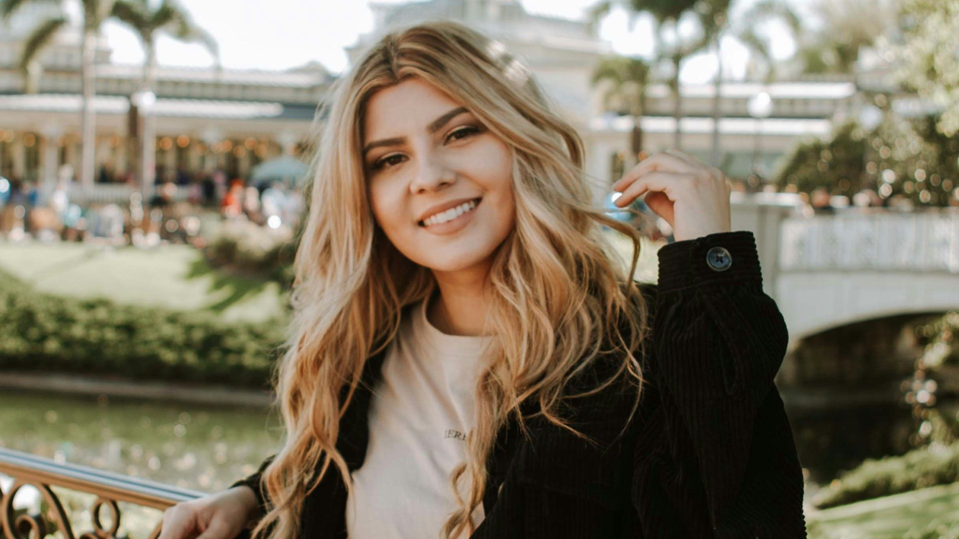 woman in black jacket and brown pants standing on bridge during daytime