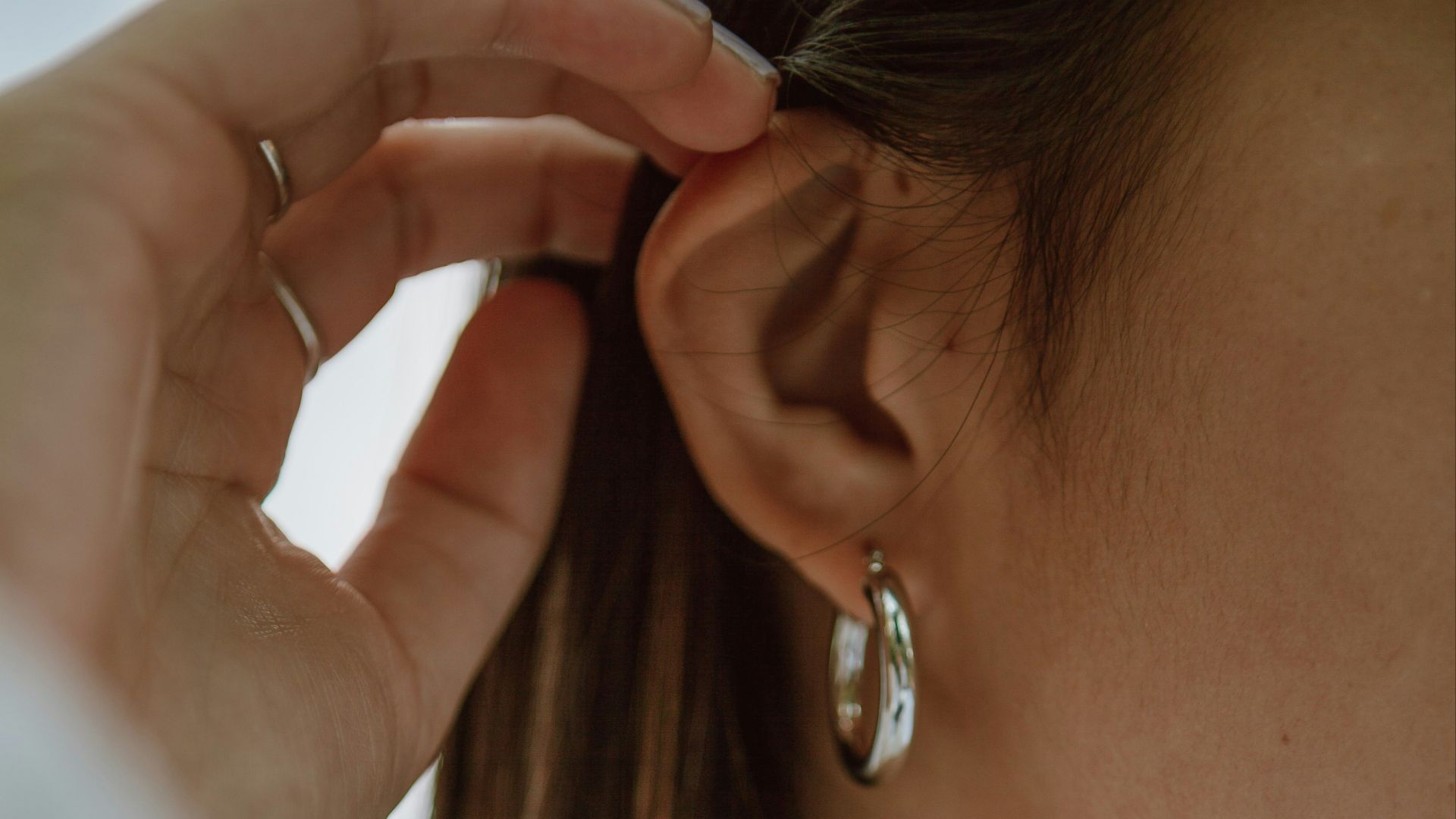 woman in white shirt wearing gold necklace