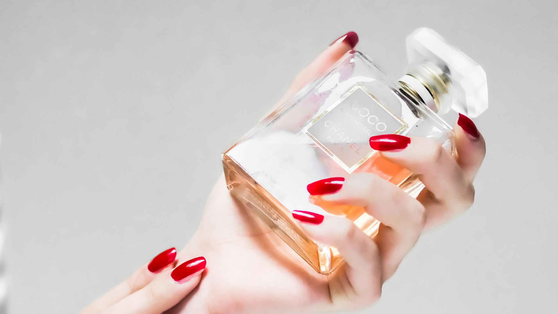 person holding clear glass bottle