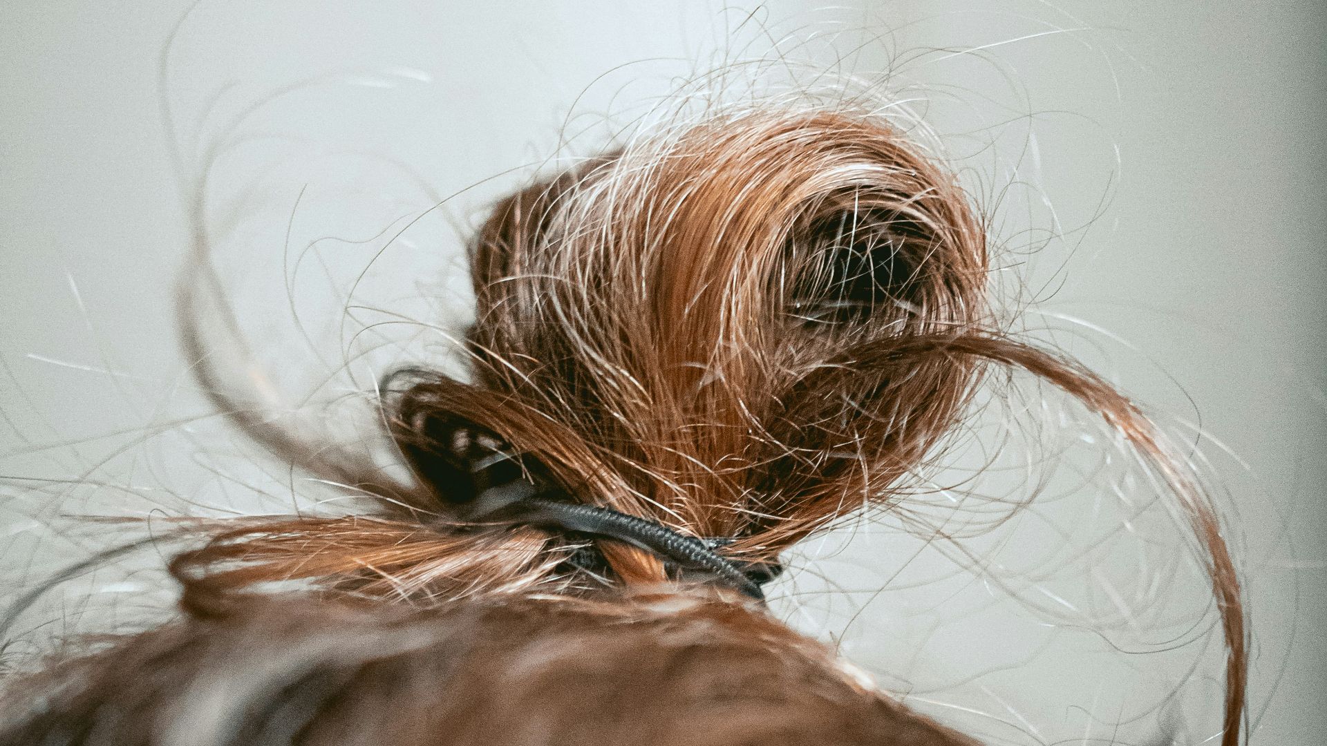 blonde hair tied with black rubber band