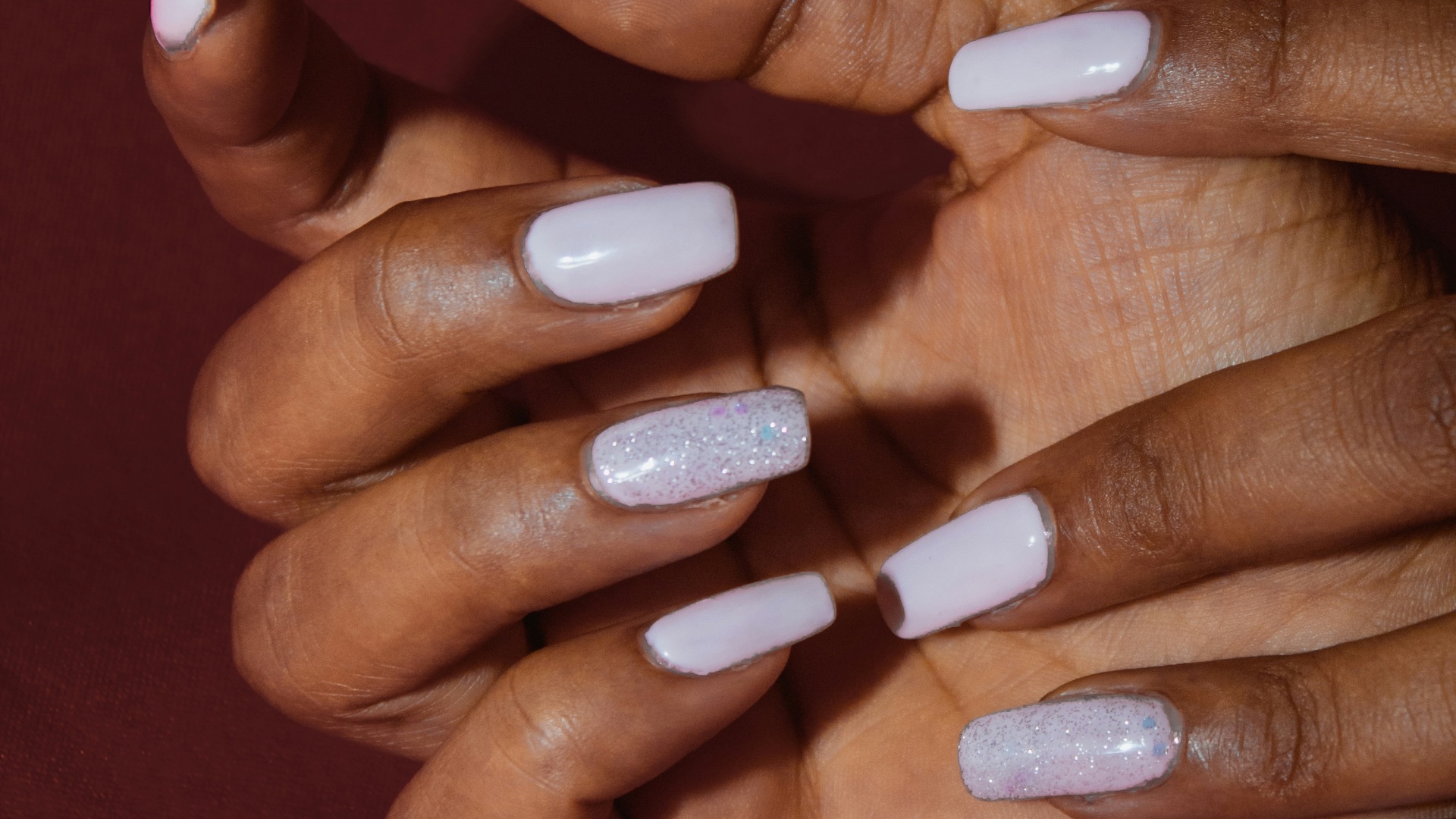a woman's hands with white nail polish on them