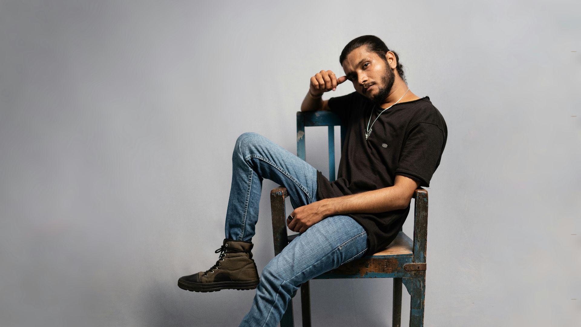 a man sitting on top of a wooden chair