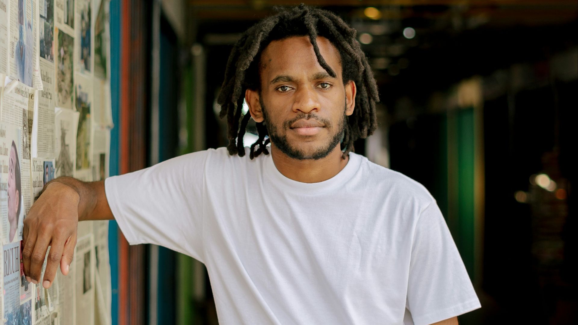 man in white crew neck t-shirt wearing black headphones