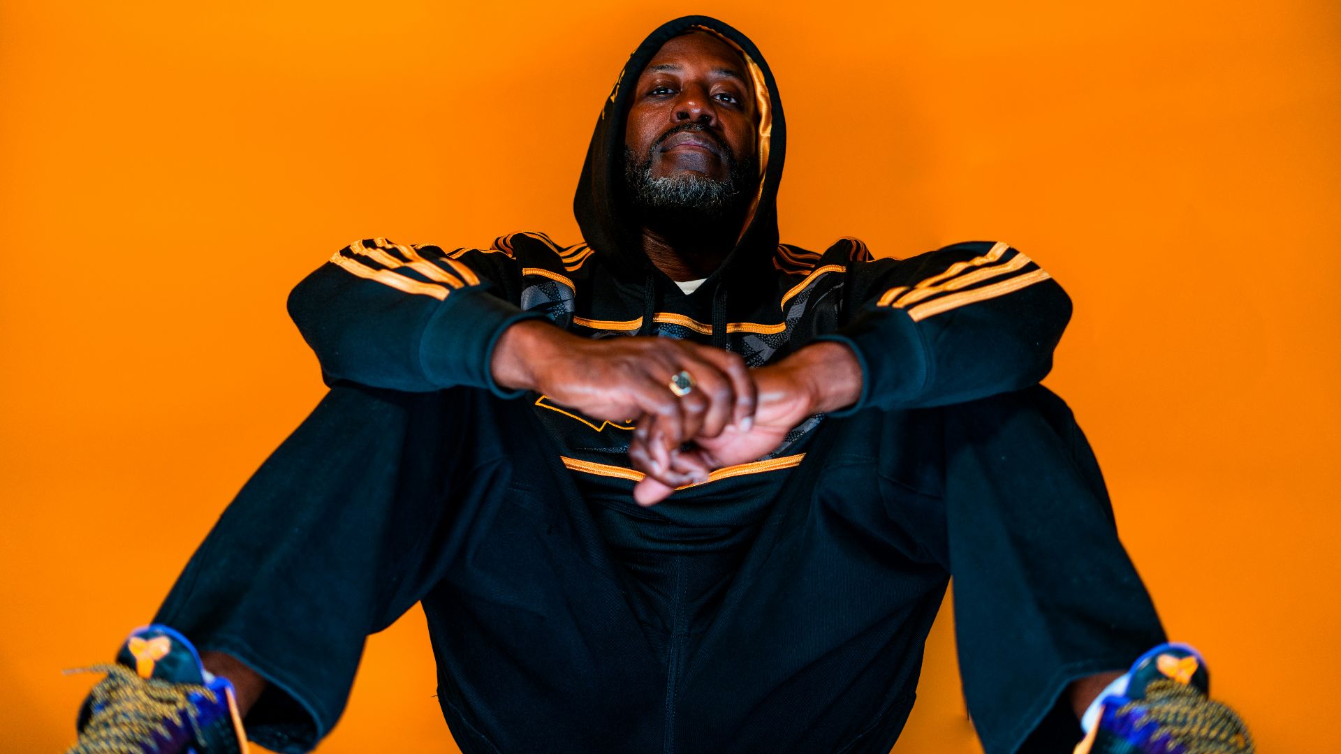 man sitting on ground with both hands on knees