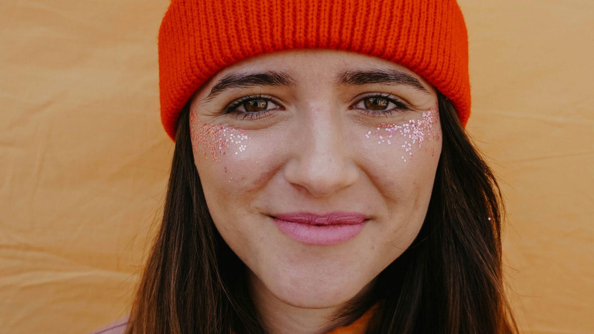 woman in orange knit cap smiling