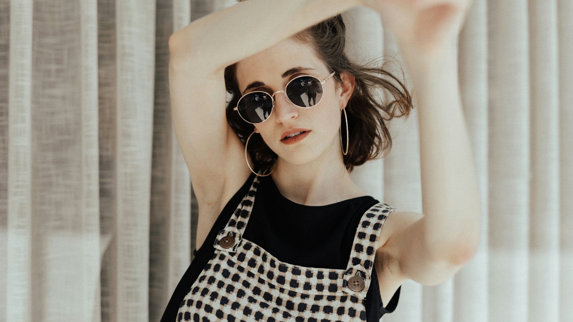 woman in black tank top near curtain