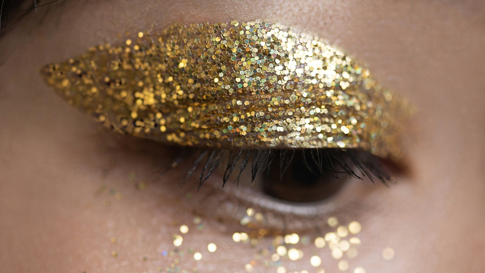 a woman with gold glitter on her eyes