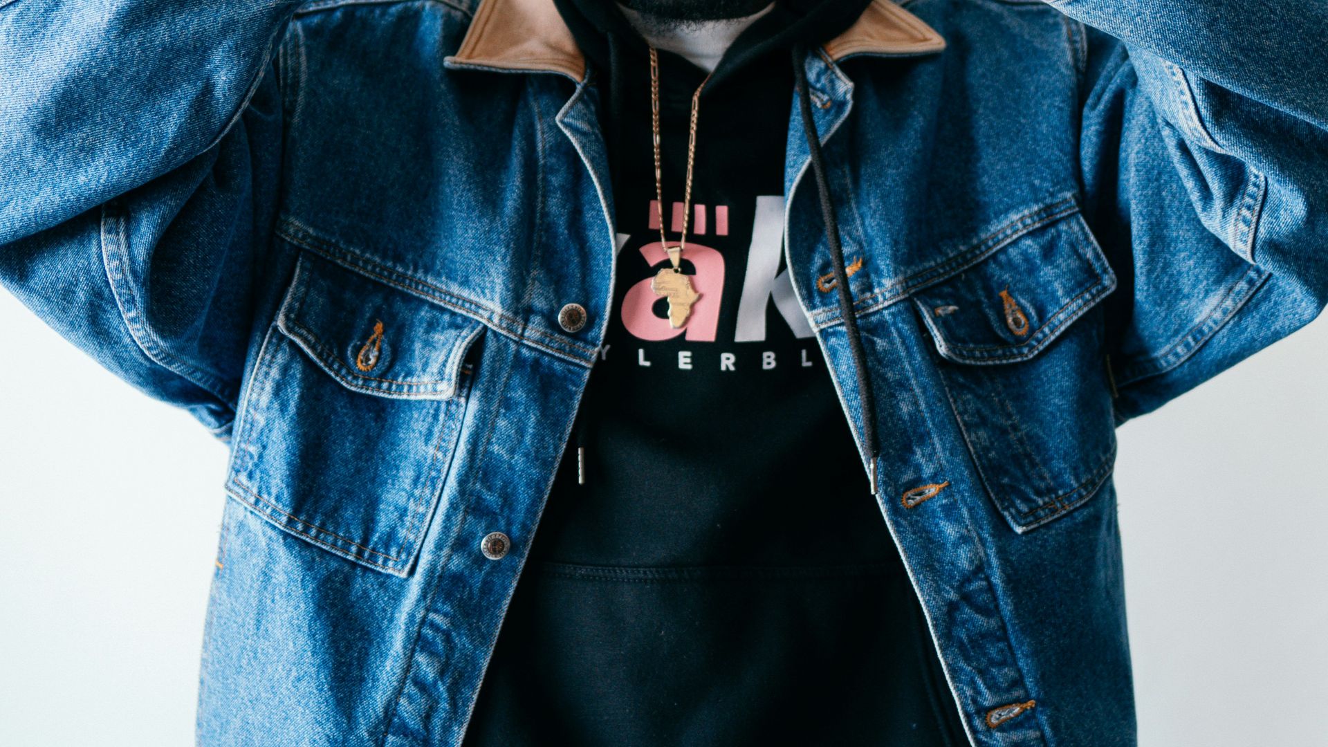 man in blue denim jacket and black fitted cap