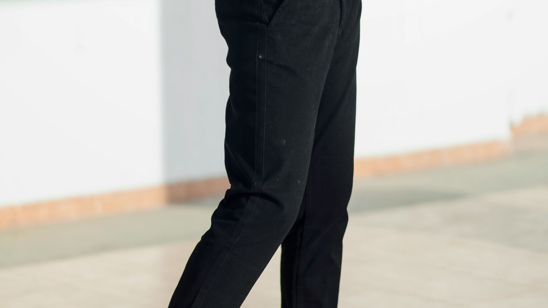 man in white t-shirt and black pants standing on white floor