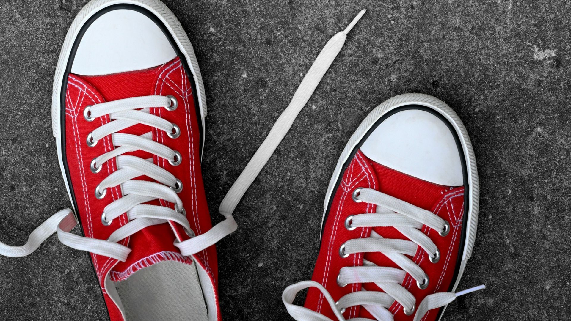 a pair of red sneakers with white laces