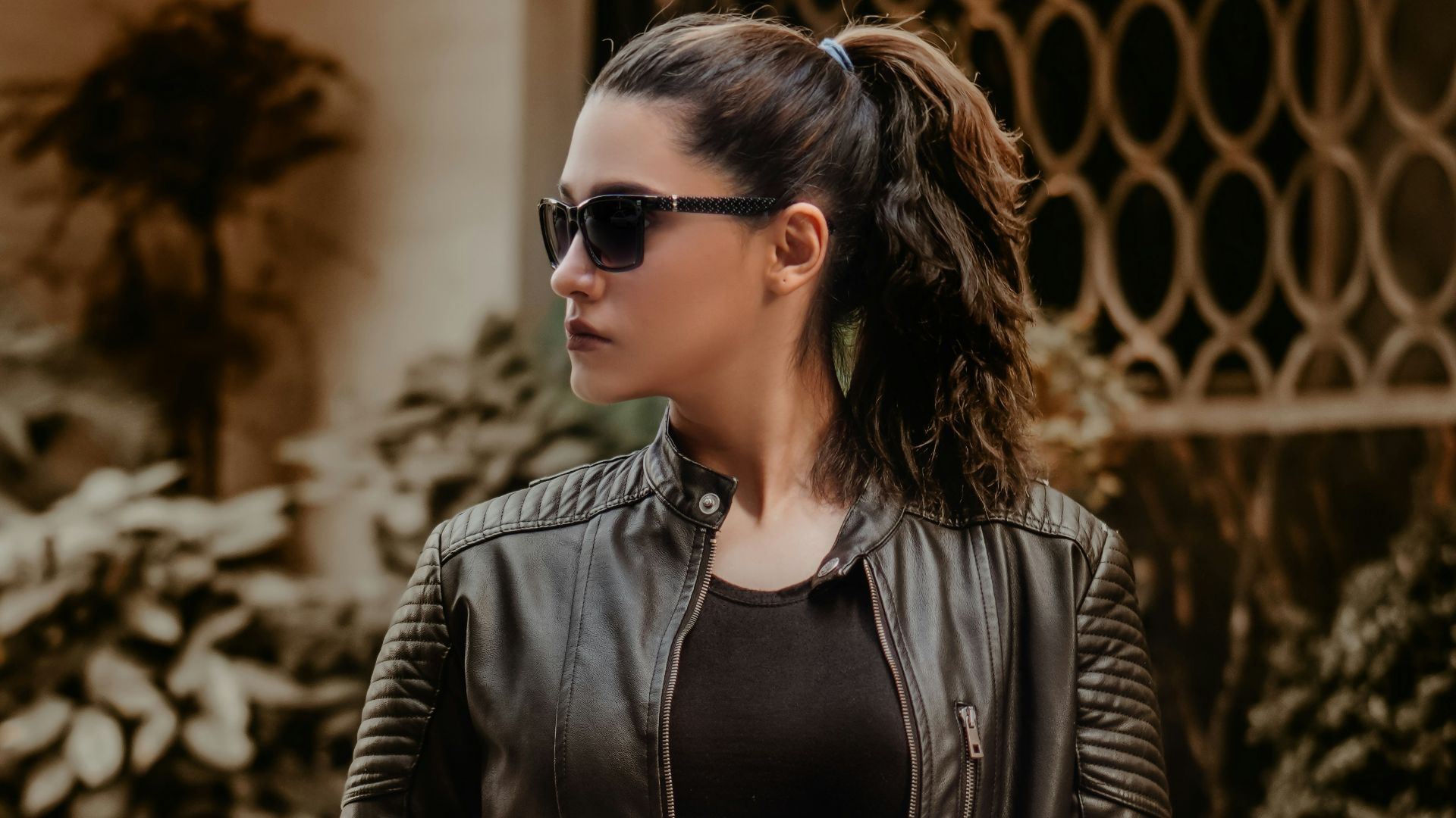 woman in black leather jacket wearing black sunglasses