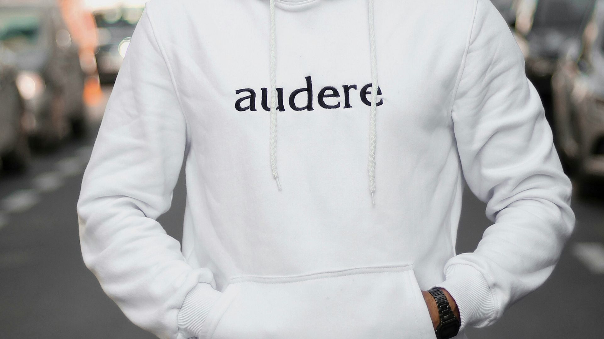 man in white pullover hoodie standing on road during daytime