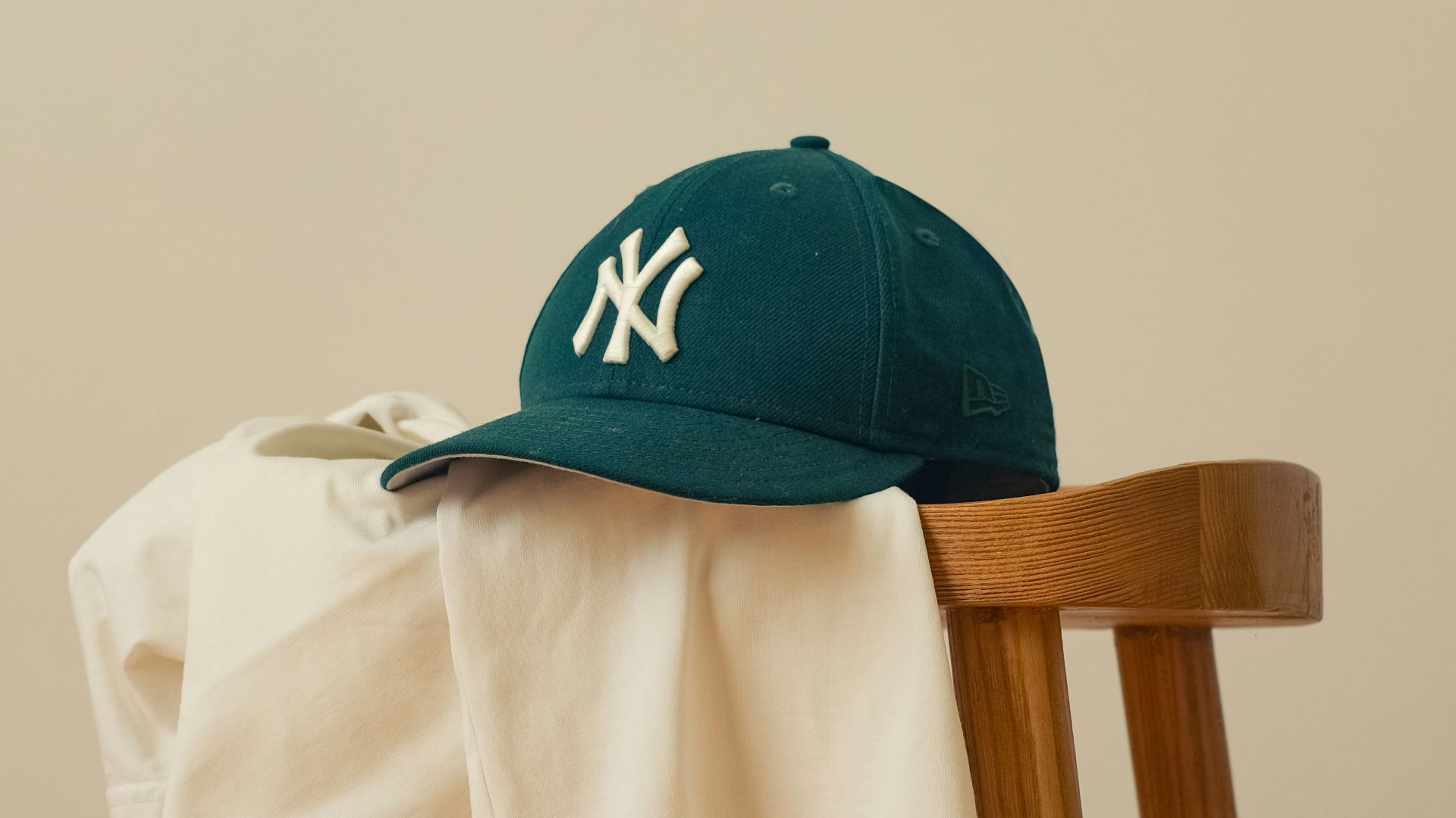 A baseball cap sitting on top of a wooden chair