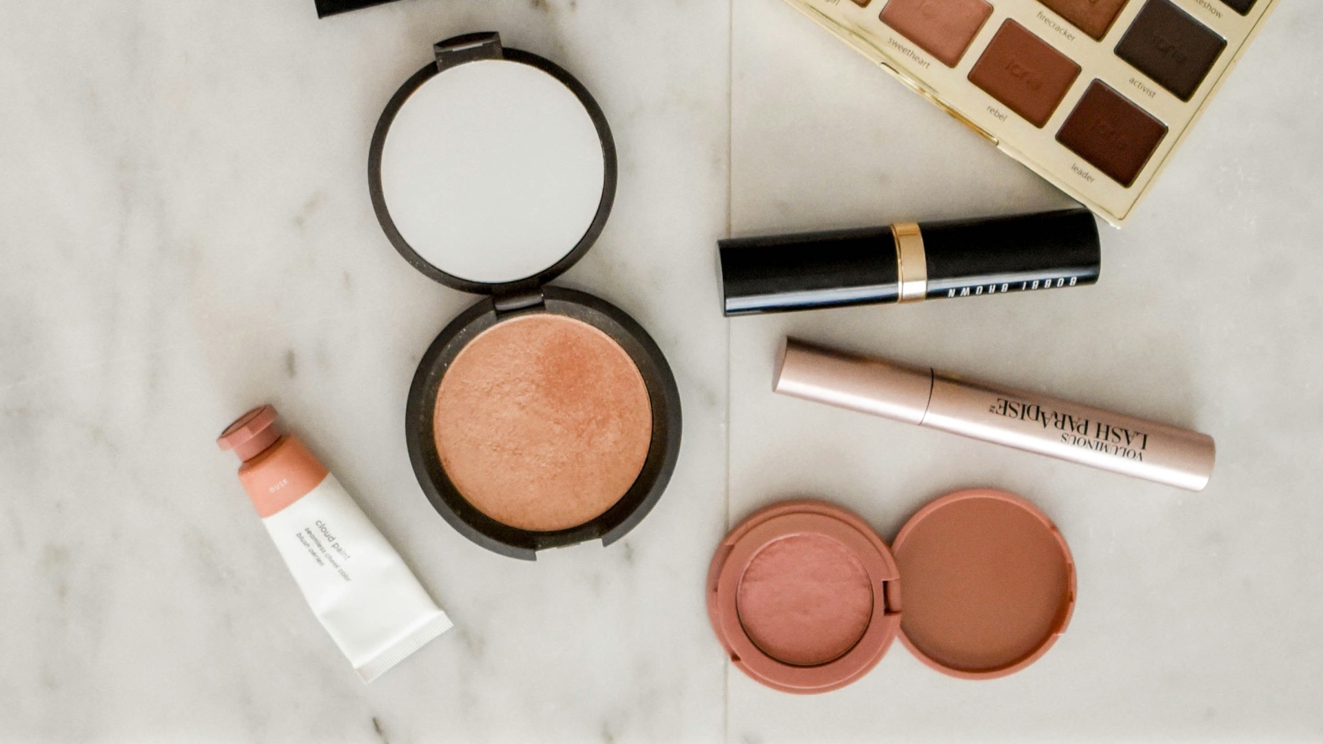 photo of assorted makeup products on gray surface