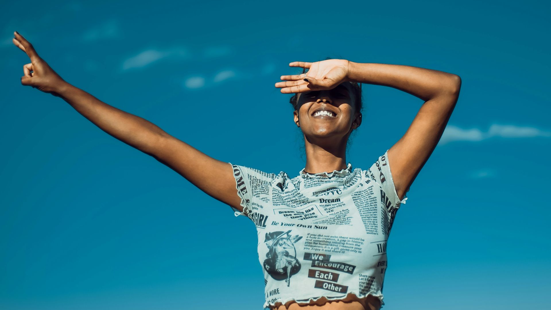 a woman standing in a field with her arms outstretched