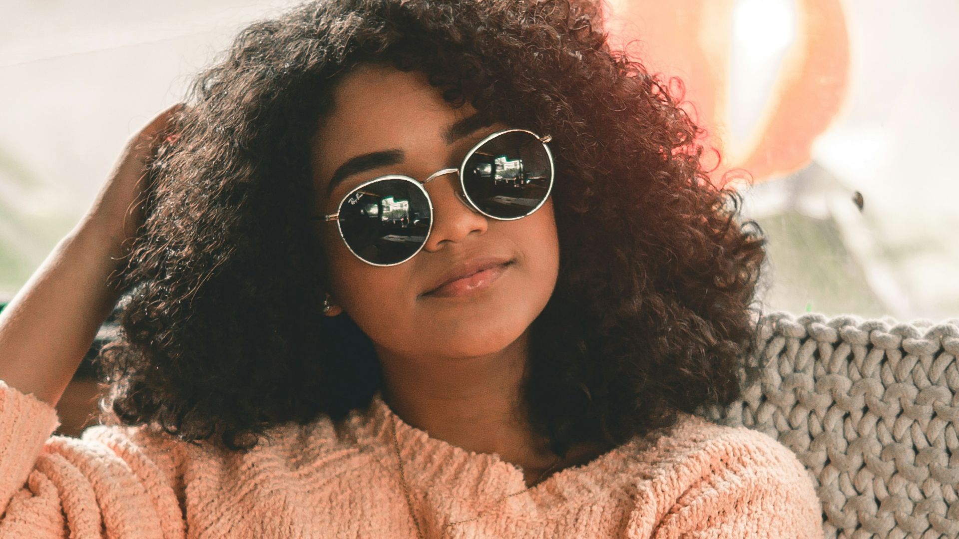 woman sitting on chair leaning on window