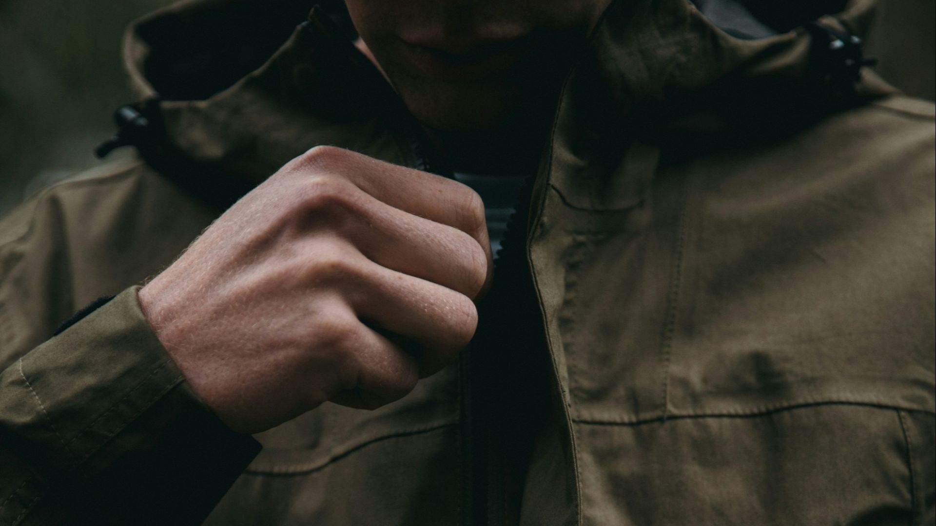 person zipping up brown hoodie