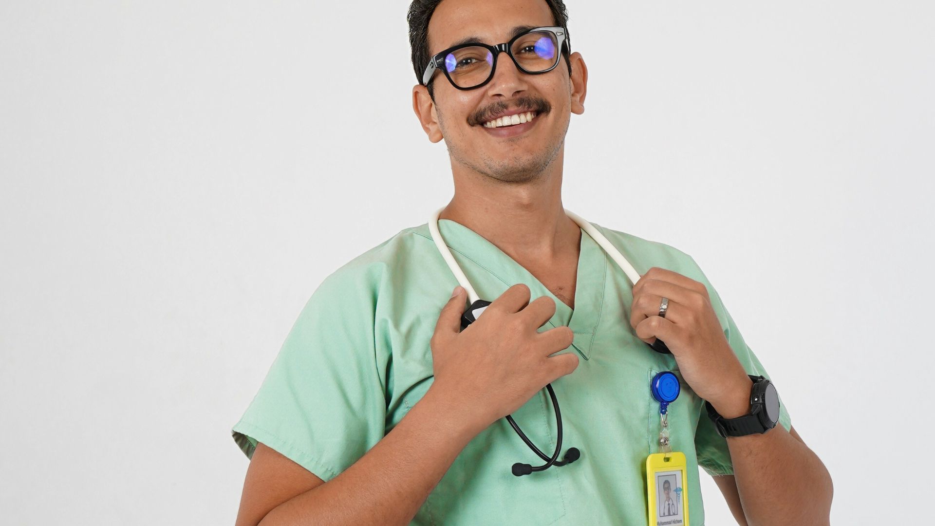 A man in a green scrub suit holding a toothbrush