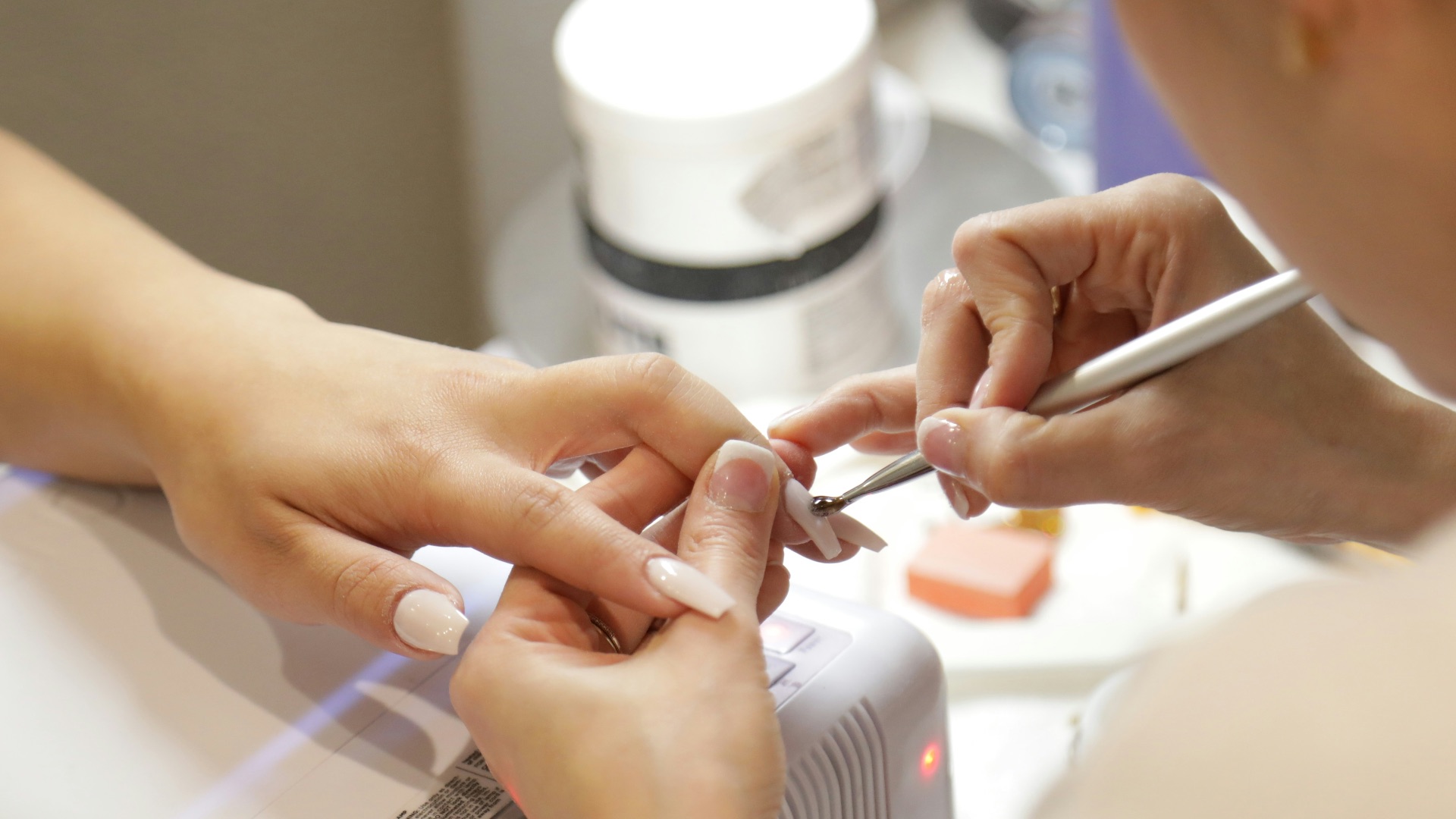 a woman getting her nails done at a nail salon