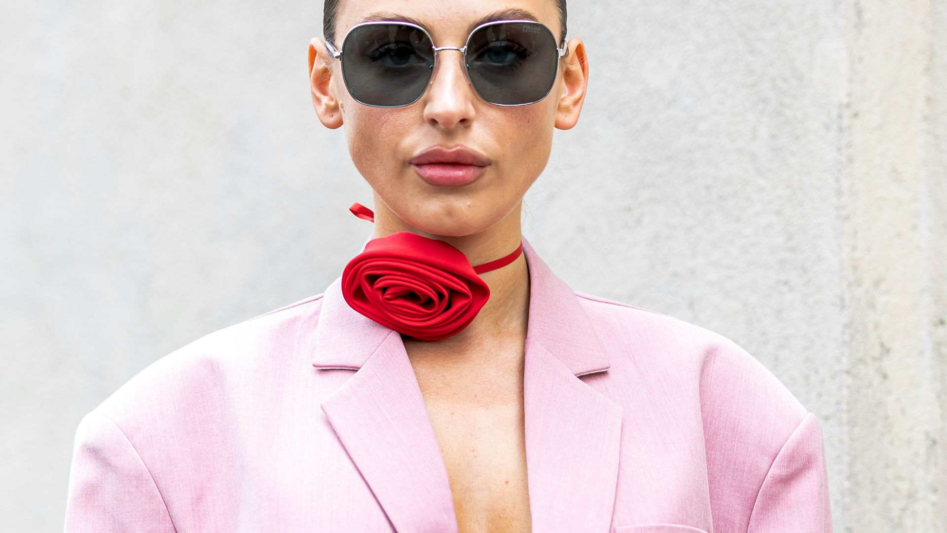 a woman wearing a pink suit and sunglasses