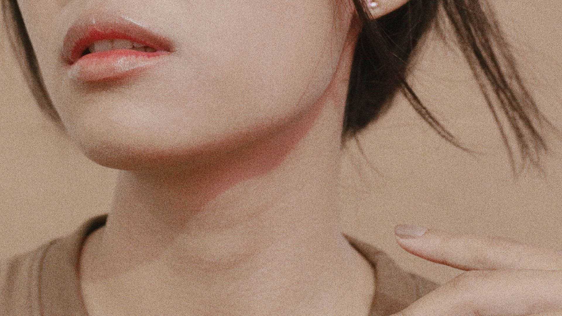 a woman wearing a pair of earrings and a brown shirt