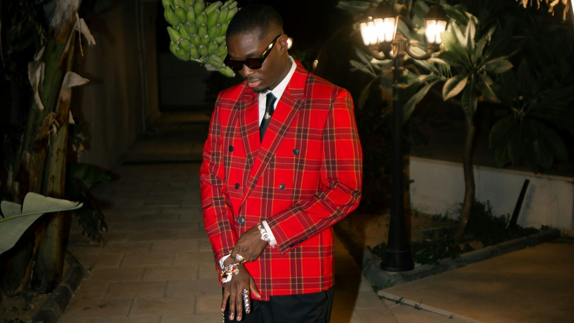 Man in red plaid suit and black shorts